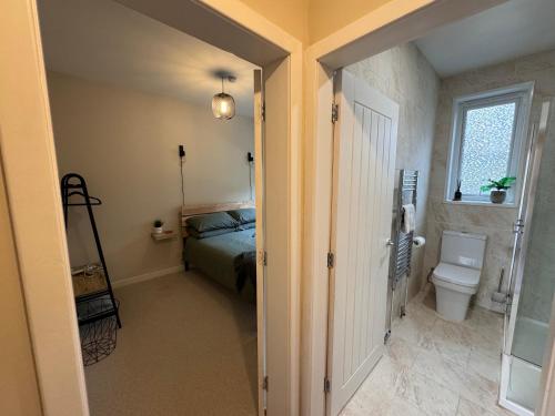 a bedroom with a bed and a toilet and a window at Waternish Apartment in Corpach
