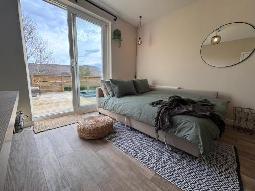 a bedroom with a bed and a large window at Waternish Apartment in Corpach