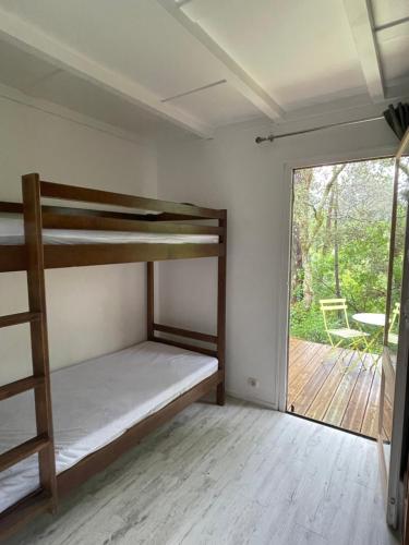 a room with bunk beds and a sliding glass door at Les fougères A81 Les villages sous les pins LEON 40550 in Léon