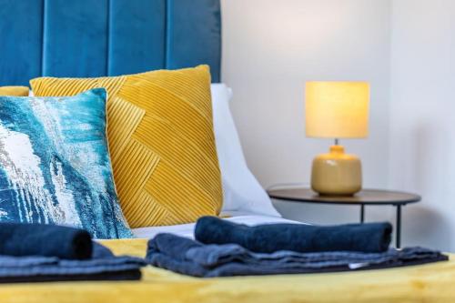 ein Bett mit blauen Kissen und einem Tisch mit einer Lampe in der Unterkunft Central Winchester Apartment with Free Parking Sleeps 6 in Winchester