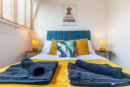 ein Schlafzimmer mit einem Bett mit blauen Kissen darauf in der Unterkunft Central Winchester Apartment with Free Parking Sleeps 6 in Winchester