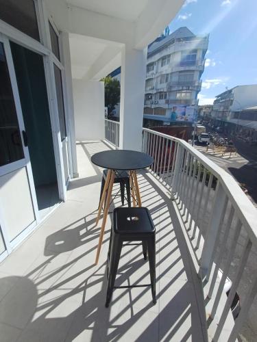 a black table on a balcony with a stool at A340 citi center room in Papeete