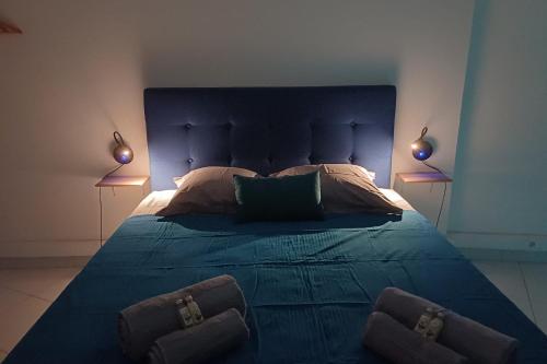 a bedroom with a large blue bed with two lamps at A340 citi center room in Papeete
