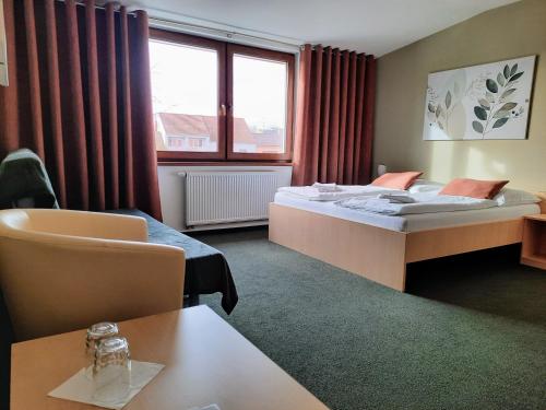 a hotel room with a bed and a table at Penzion Maděřič in Moravský Žižkov