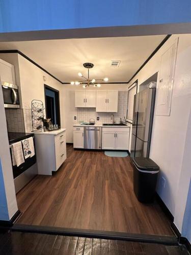 a large kitchen with white cabinets and wood floors at Relaxing Home in Savannah, Ga area in Savannah