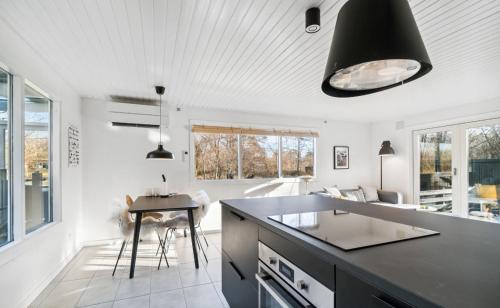Vester Sømarken的住宿－Lovely Summer House With Bornholm Atmosphere,，厨房配有黑色台面和桌子