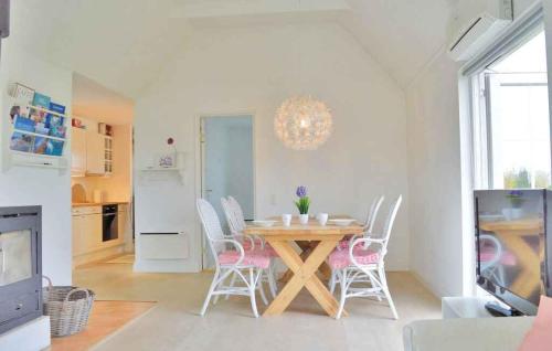 cocina y comedor con mesa y sillas en Modern Cottage Close To The Beach, en Vejby