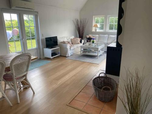 sala de estar con sofá y mesa en Modern Cottage Close To The Beach, en Vejby