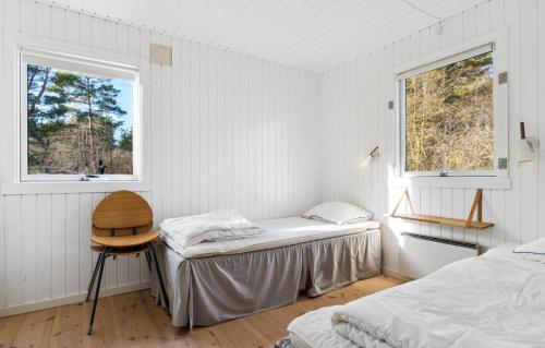 1 dormitorio con 2 camas y 2 ventanas en Lovely Summer House With Bornholm Atmosphere, en Vester Sømarken