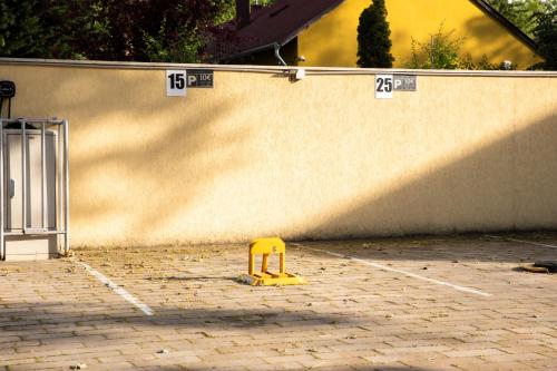 a yellow object in a parking lot next to a wall at Casa Luxury Wellness Apartman By BLTN in Siófok