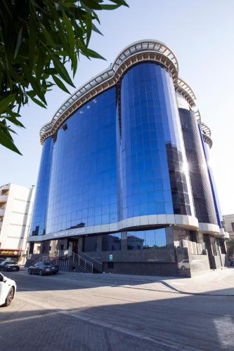 a large glass building with a curved roof at Aluya Hotel in Jeddah