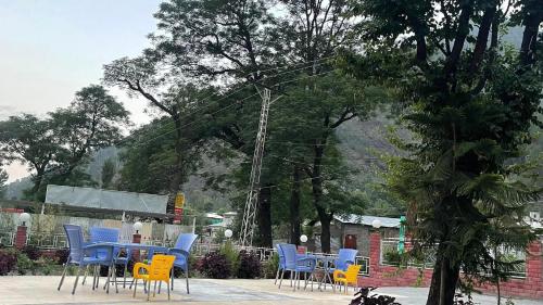 a group of blue and yellow tables and chairs at Red Rose Hotel in Bālākot