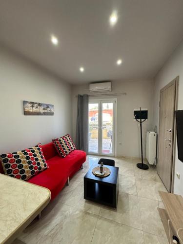 Kanálion的住宿－Studio One，客厅配有红色的沙发和桌子