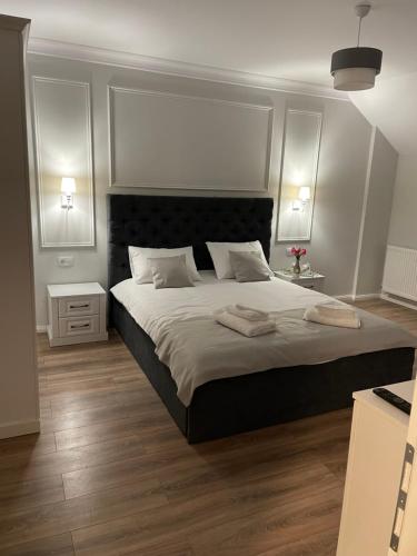 a bedroom with a large bed with two towels on it at Royal Boutique in Râşnov