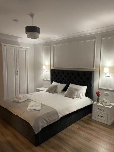 a bedroom with a large bed with a black headboard at Royal Boutique in Râşnov