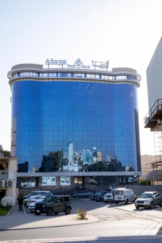 a blue building with cars parked in a parking lot at Aluya Hotel in Jeddah