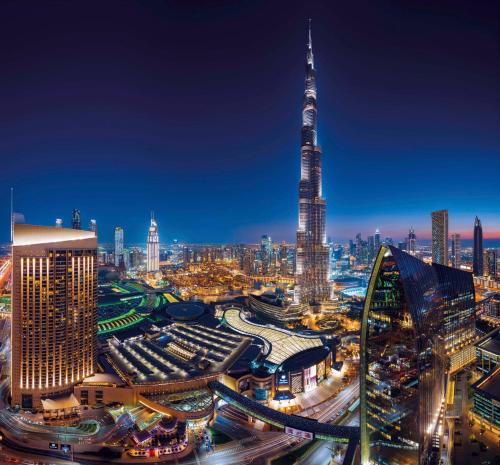 Una ciudad de noche con el edificio más alto del mundo en Kempinski Central Avenue Dubai en Dubái