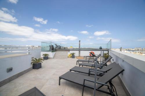 a row of chairs on the roof of a building at Park Heights by the Warren Collection in Msida
