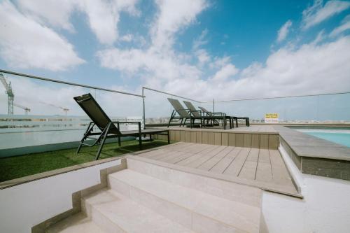 a patio with chairs and a table on a roof at Park Heights by the Warren Collection in Msida