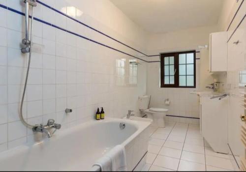 uma casa de banho branca com uma banheira e um WC em Acorn Cottage em Glenbeigh