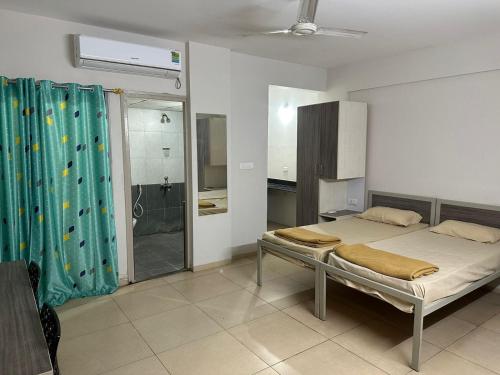 um quarto com uma cama e uma casa de banho com um chuveiro em POP 82272C Townhouse Oak- Seven Olives em Bangalore