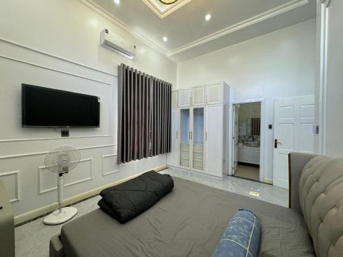 ein Wohnzimmer mit einem Sofa und einem Flachbild-TV in der Unterkunft Villa for rent in Tra Vinh City in Xóm Vàng