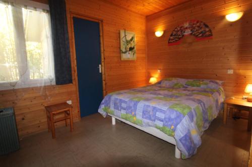 a bedroom with a bed in a wooden room at Gasgol11 - Golfe de St-Tropez - Chalet dans coin de verdure in Gassin