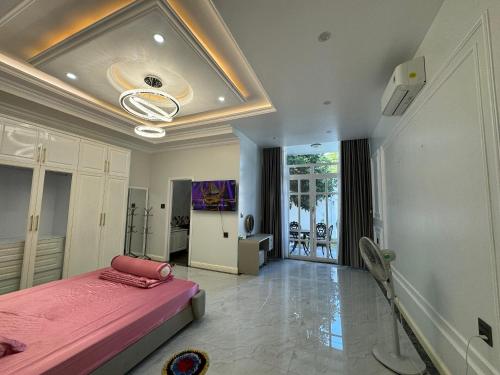ein Schlafzimmer mit einem rosa Bett und einer Decke in der Unterkunft Villa for rent in Tra Vinh City in Xóm Vàng