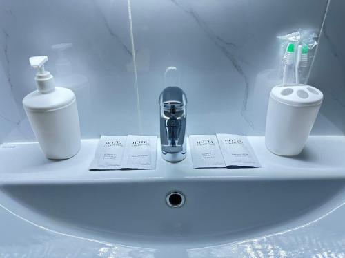 un lavabo con cepillo de dientes y una botella de pasta de dientes en Esil Riverside Elite Apartments en Astaná