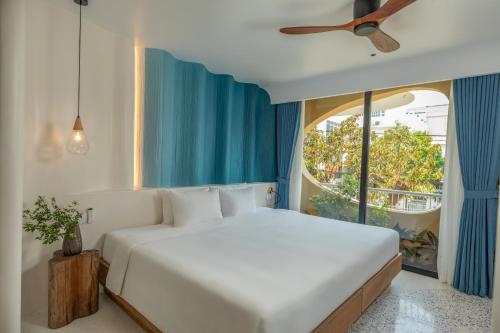 a bedroom with a white bed and a large window at Saha Casa Boutique Hotel Da Nang in Da Nang