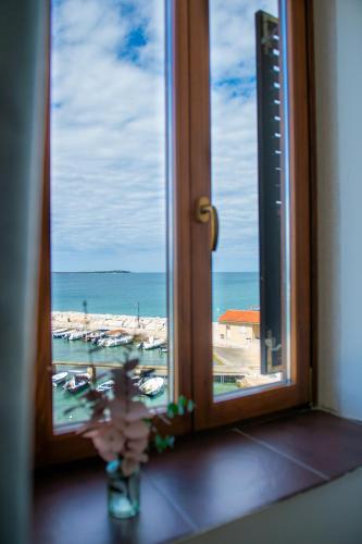 a window with a view of a beach and the ocean at Hotel Marina in Fažana