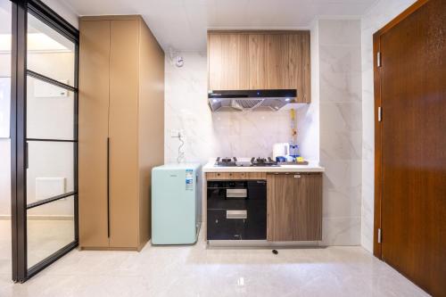 a kitchen with a refrigerator and a stove at 岗厦轻居-深圳福田会展中心岗厦地铁站店 in Shenzhen