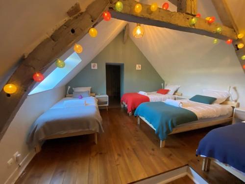 Schlafzimmer im Dachgeschoss mit 3 Betten in einem Zimmer in der Unterkunft Longère des 1001 étoiles in Renay