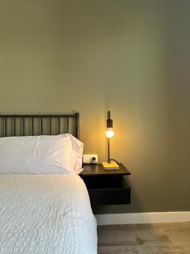 a bedroom with a bed and a lamp on a table at Apartamentos Vernia Ontinyent in Ontinyent