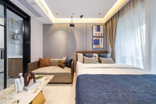 een slaapkamer met 2 bedden en een bank bij Gangxia International Hotel-深圳福田会展中心岗厦地铁站店 in Shenzhen