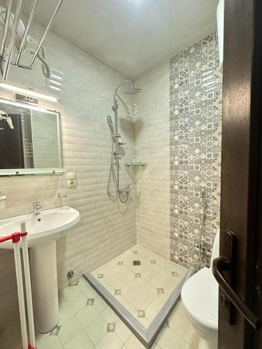 a bathroom with a shower and a toilet and a sink at Aqua Batumi 47 in Batumi