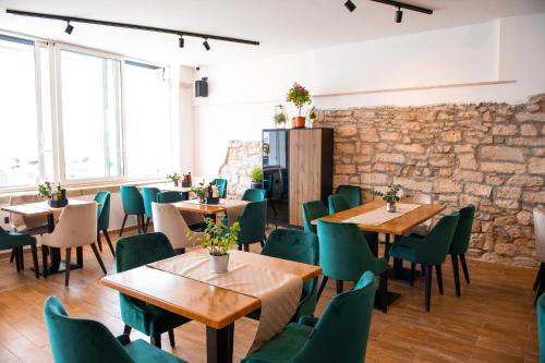 um restaurante com mesas de madeira e cadeiras verdes em Hotel Marina em Fažana