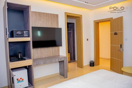 Zimmer mit einem TV und einem Bett in einem Zimmer in der Unterkunft Polo Grand Hotel in Maiduguri
