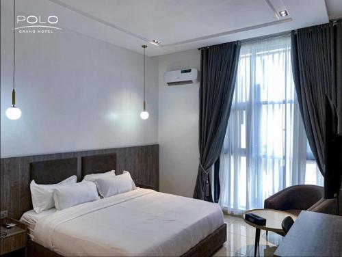 ein Hotelzimmer mit einem Bett und einem Fenster in der Unterkunft Polo Grand Hotel in Maiduguri