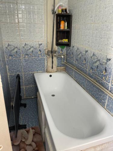 a bath tub in a bathroom with blue tiles at CBT1 Sary-mogul in Sary-Mogul