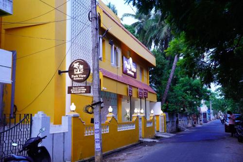 żółty budynek po stronie ulicy w obiekcie Park View Residency w mieście Puducherry
