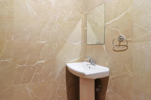 a bathroom with a sink and a mirror at Hotel Mint Residency - Dwarka Sector 9 in New Delhi