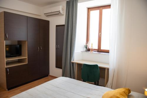 a bedroom with a bed and a desk and a window at Hotel Marina in Fažana