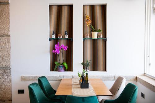 a dining room with a table and green chairs at Hotel Marina in Fažana