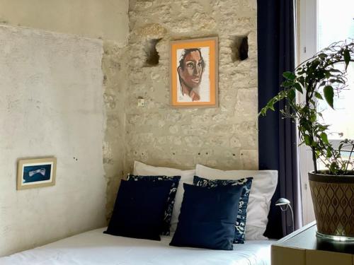 - une chambre avec un lit doté d'oreillers bleus et d'un tableau dans l'établissement Maison des 4 Saisons by Melrose, à Bayeux