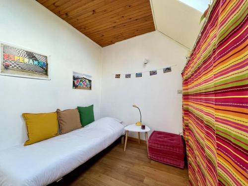 Cette chambre dispose d'un lit et d'un mur coloré. dans l'établissement Maison des 4 Saisons by Melrose, à Bayeux