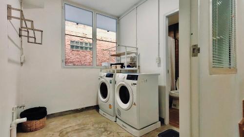 a laundry room with a washing machine and a window at Whole 3-storey house right in the local community. in Bangkok