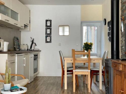 une cuisine et une salle à manger avec une table et des chaises dans l'établissement Maison des 4 Saisons by Melrose, à Bayeux