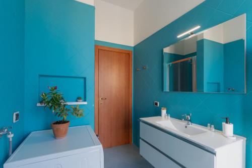een blauwe badkamer met een wastafel en een spiegel bij Sorrento Main Road Apartment in Sorrento