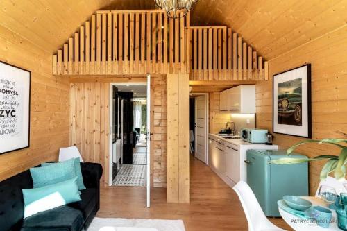 uma cozinha e uma sala de estar numa casa de madeira em Trzy Domki w Mielnie em Mielno